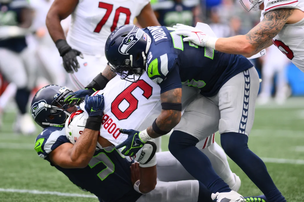 Oct 22, 2023; Seattle, Washington, USA; Seattle Seahawks linebacker Bobby Wagner (54) and safety Jamal Adams (33) tackle Arizona Cardinals quarterback Joshua Dobbs (9) during the first half at Lumen Field. Mandatory Credit: Steven Bisig-USA TODAY Sports