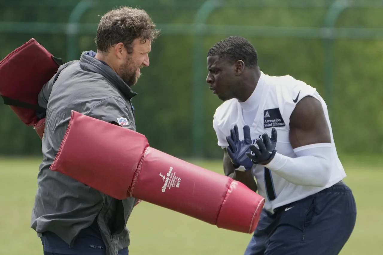 Tennessee Titans linebacker Oluwafemi Oladejo, right, works with outside linebackers coach Ben Bloom, left, after an NFL football practice Wednesday, May 28, 2025, in Nashville, Tenn. (AP Photo/George Walker IV)