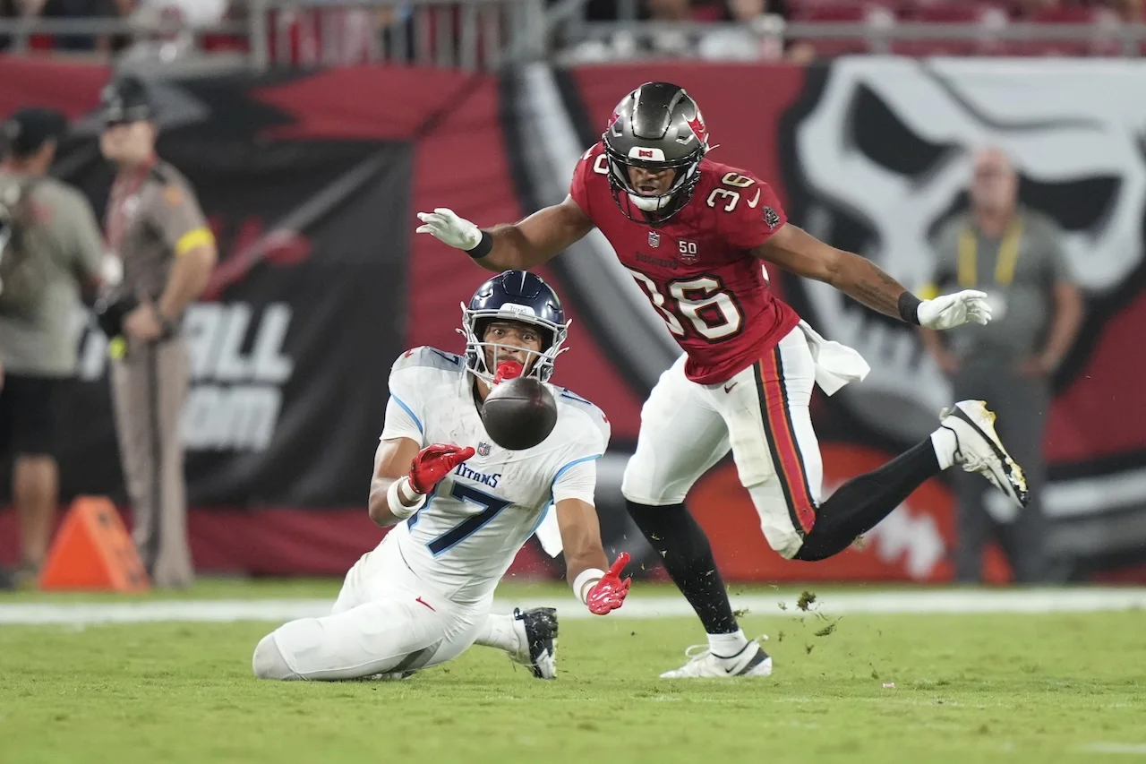 Tennessee Titans linebacker Oluwafemi Oladejo (7) tries to make a sliding catch as Tampa Bay Buccaneers safety JJ Roberts (36) defends during a preseason NFL football game , Saturday, Aug. 9, 2025, in Tampa, Fla. (AP Photo/Peter Joneleit)