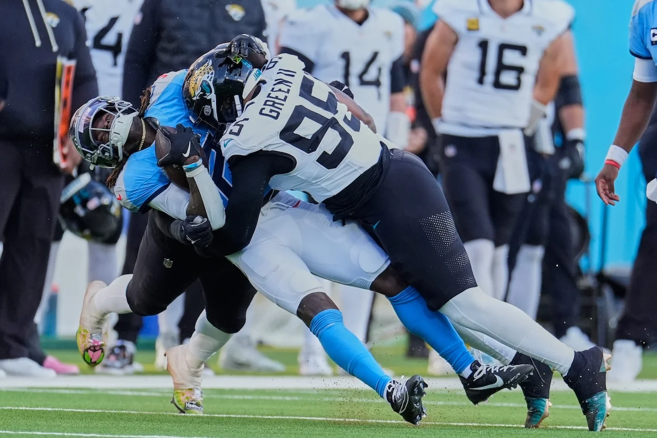 Tennessee Titans running back Tyjae Spears, left, is hit by Jacksonville Jaguars defensive end BJ Green II (95) during the second half of an NFL football game Sunday, Nov. 30, 2025, in Nashville, Tenn. (AP Photo/George Walker IV)