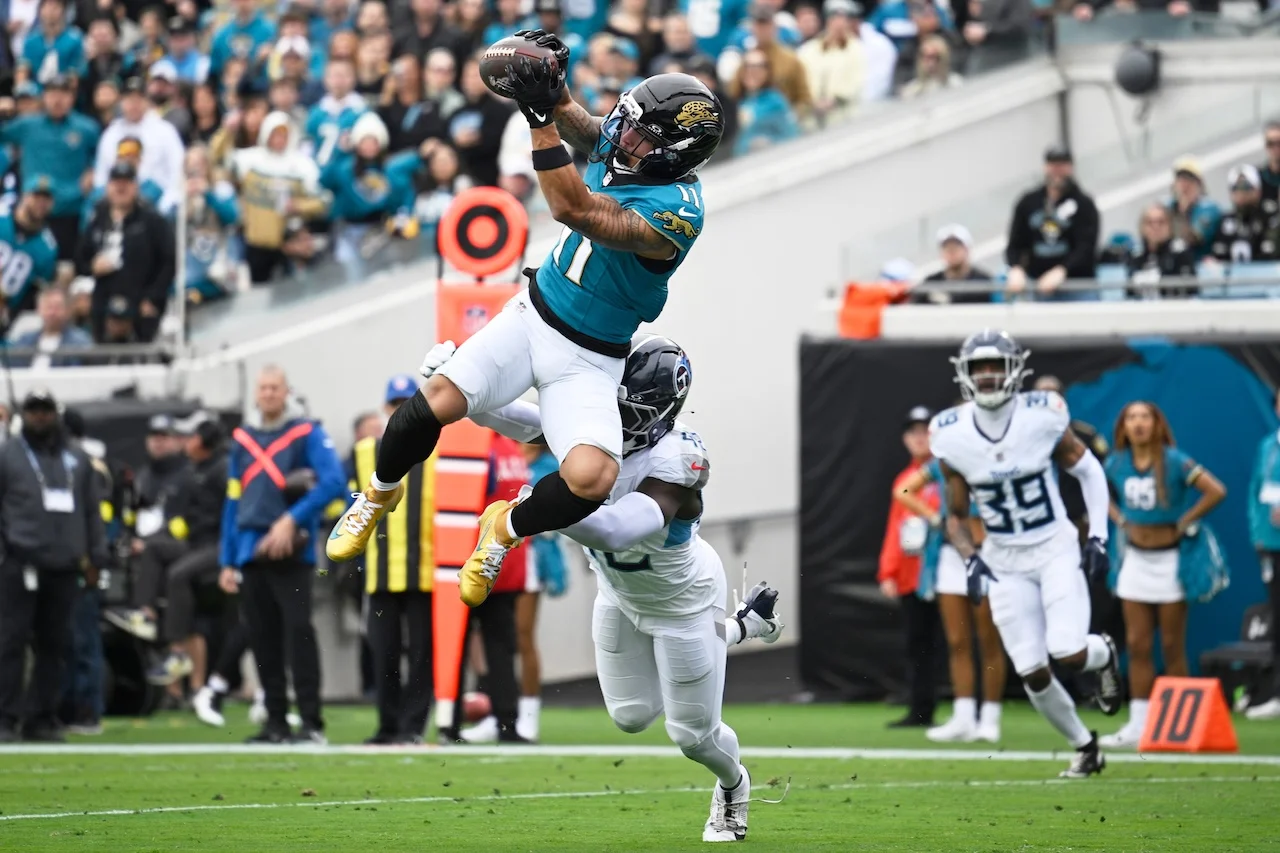 Jacksonville Jaguars wide receiver Parker Washington (11) makes a catch for a touchdown over Tennessee Titans safety Sanoussi Kane, below, during the first half of an NFL football game Sunday, Jan. 4, 2026, in Jacksonville, Fla. (AP Photo/Phelan M. Ebenhack)