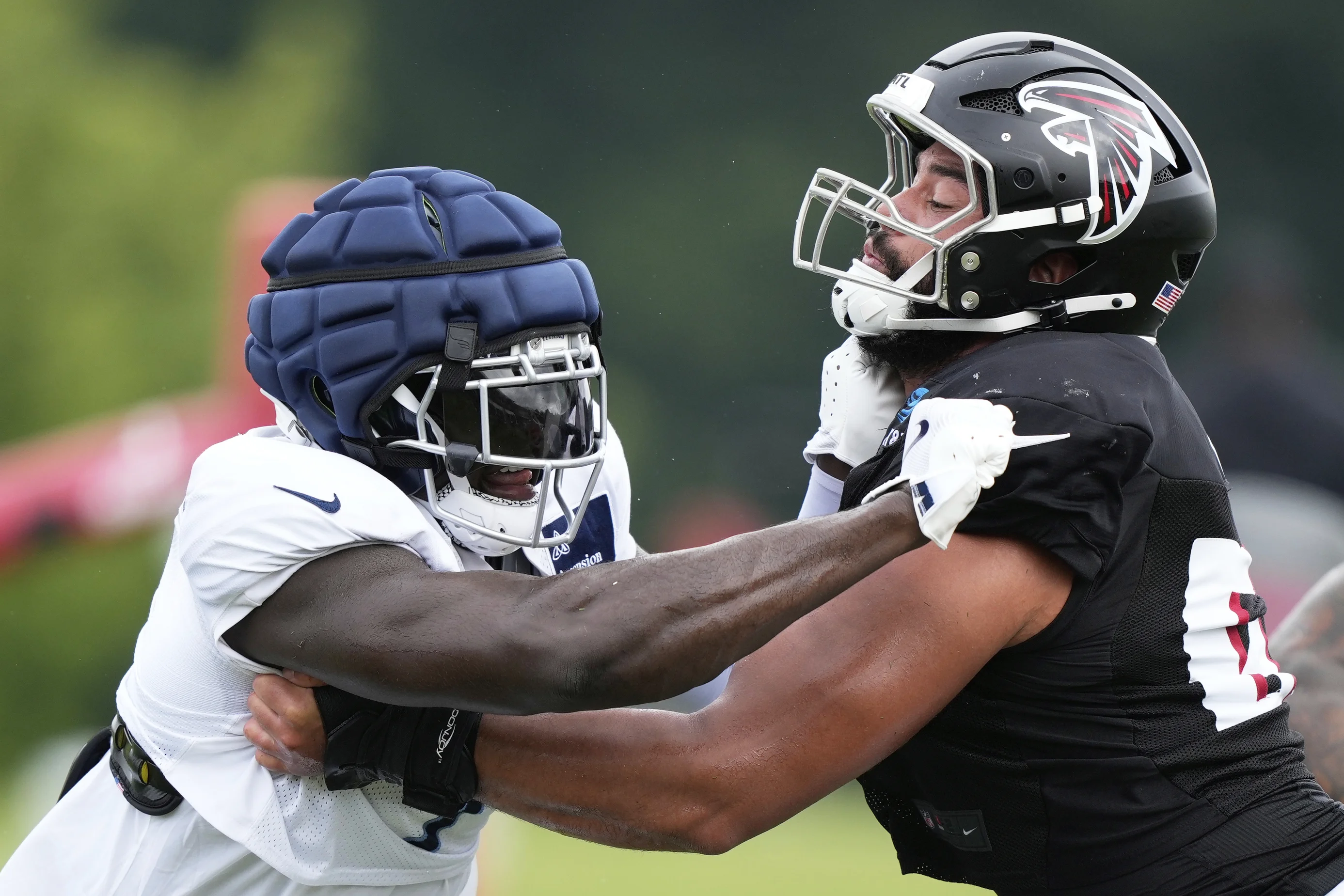 Tennessee Titans linebacker Oluwafemi Oladejo (7) runs drills with Atlanta Falcons guard Joshua Gray (67) during an NFL joint football practice on Tuesday, Aug. 12, 2025, in Flowery Branch, Ga. (AP Photo/Brynn Anderson)